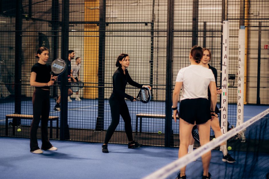 Een padelracket met middenbalans, perfect voor controle en kracht op de padelbaan, met een speler in actie.